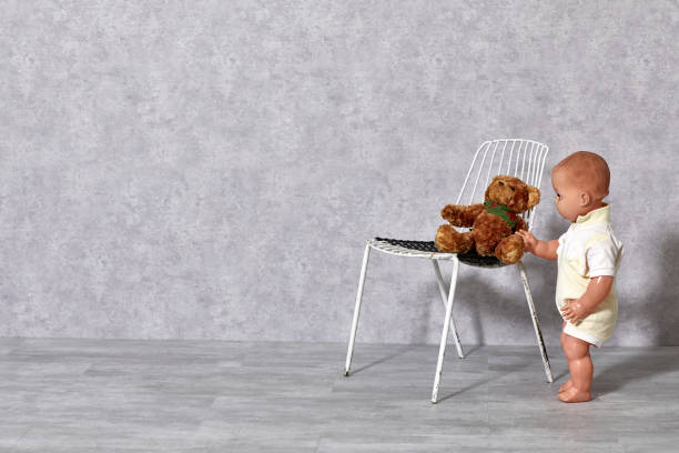 istock White metal chair, teddy bear and boy puppet on gray background 1206020531