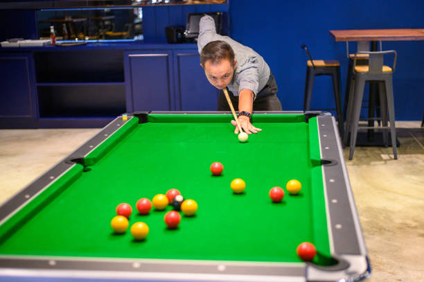 Asian Man playing pool in Bar