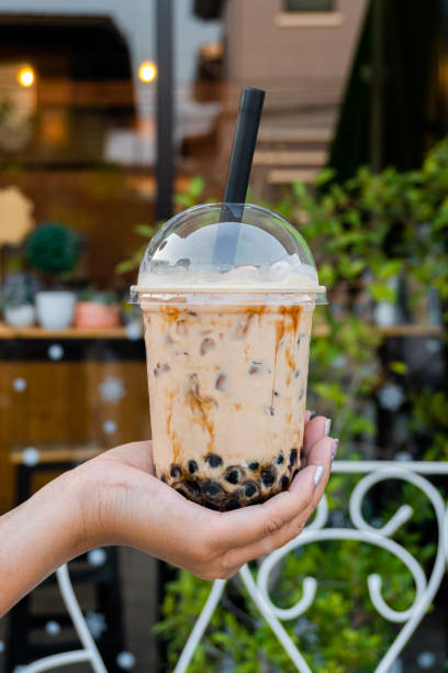 istock woman is holding a plastic cup of bubble milk tea 1206022832