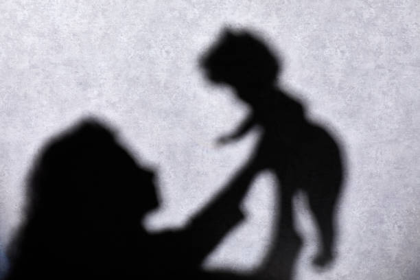 istock Silhouettes: unrecognizable woman holding baby 1206024763
