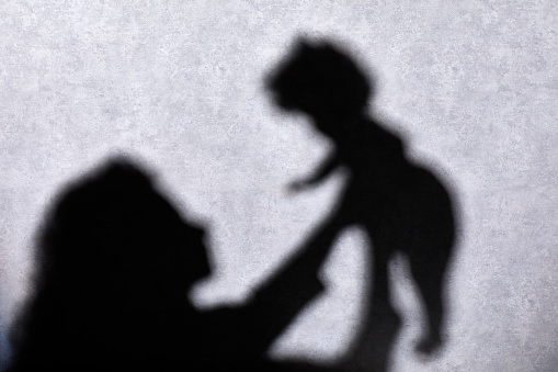 Silhouettes: unrecognizable woman holding baby