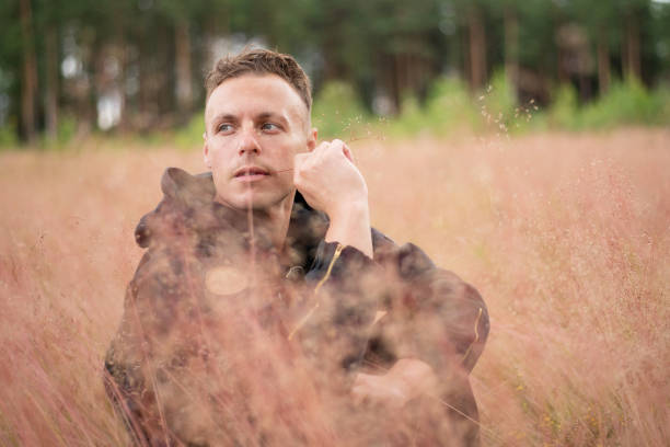 istock The man sits in a thick field, and thinks. 1206028384