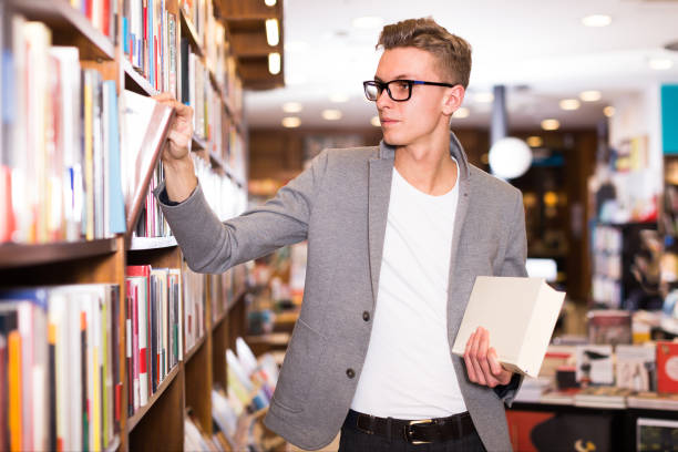 istock Glad male student choosing books on shelves 1206029674
