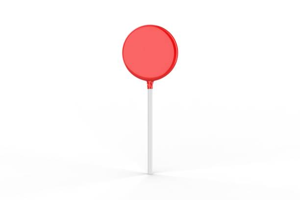 Hand holding a vibrant red lollipop against a backdrop of clear blue sky with soft white clouds, symbolizing childhood, sweetness, and simple pleasures in warm weather