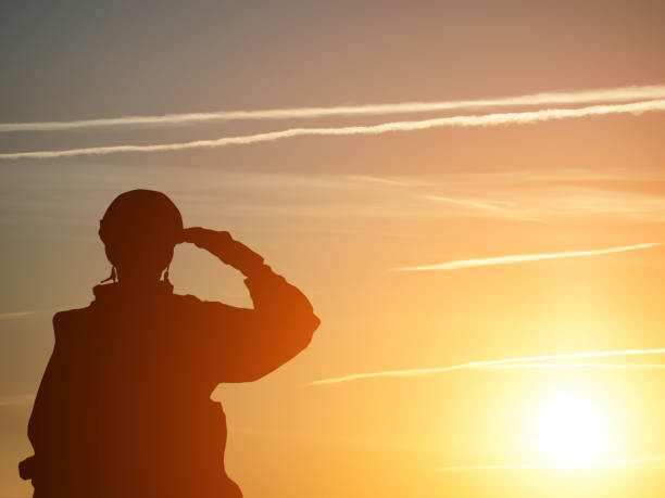 silhouette d’un solider saluant contre le lever du soleil. concept - protection, patriotisme, honneur. - saluting photos et images de collection