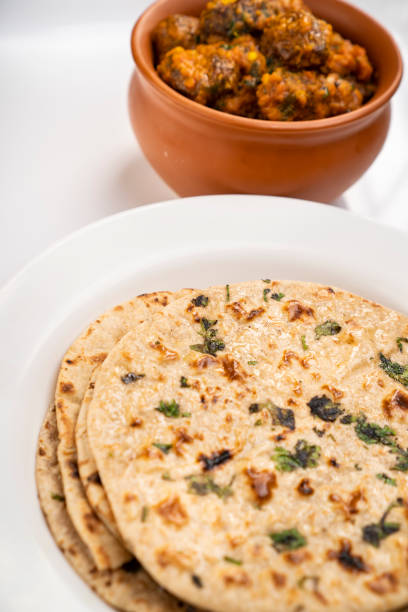istock Potato curry with chapatti (roti) served in white plate on table. 1206033417