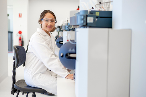Diverse female student sat working in a lab with state of the art technology . A Fourier transform spectroscopy is a measurement technique whereby spectra are collected based on measurements of the coherence of a radiative source. Research into Neurodegenerative disease and diabetes