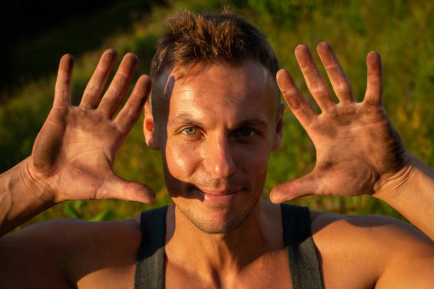 istock The man shows dirty hands, in the sunset light. 1206035271