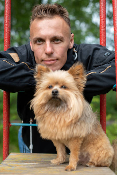 istock A man with a little dog on a swing. 1206036669