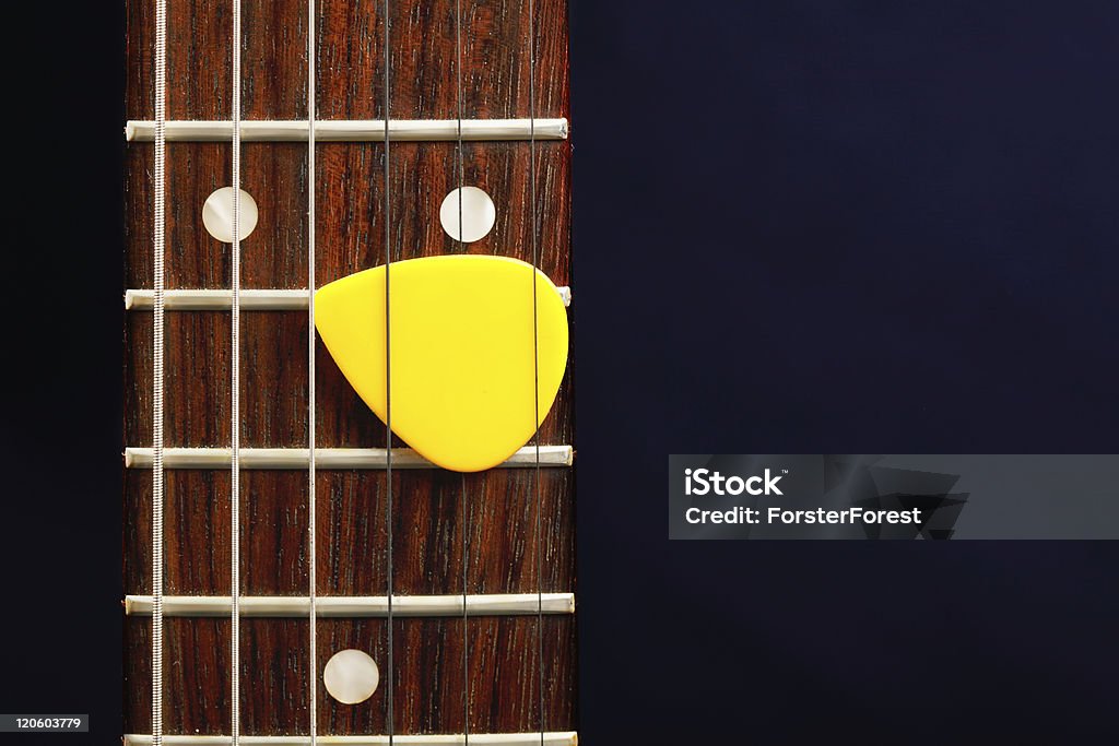 Púa de guitarra entre las cuerdas - Foto de stock de Amarillo - Color libre de derechos