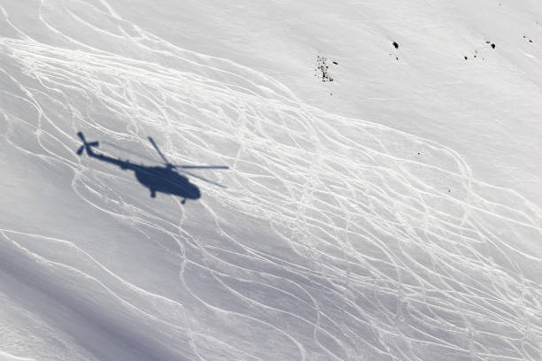 Shadow from helicopter on snowy off-piste ski slope