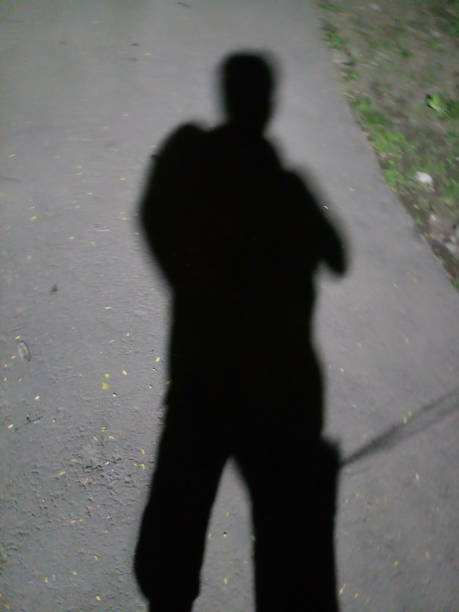 istock Black shadow of a man in night walks 1206044902