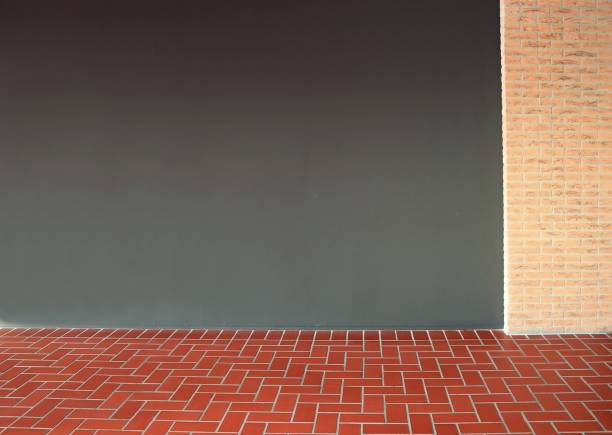 istock Dark empty gray interior wall with a column of bricks. Terracotta tiles on the floor. 1206049364
