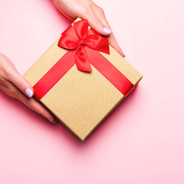 istock Woman holding gift box on pastel pink background, copyspace. Web banner, Valentine's Day greeting card, Mother's Day or Women's Day card in trendy colors, top view 1206050005
