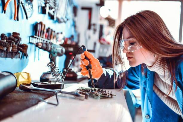 female apprentice enjoying welding practice - men baseball cap focus determination imagens e fotografias de stock