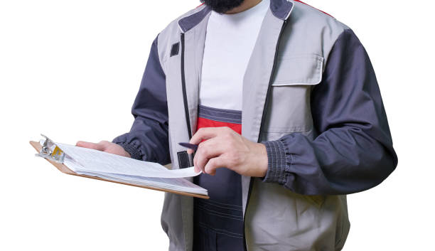 istock Concentrated young technician wearing overall standing and taking notes isolated on white background 1206051600
