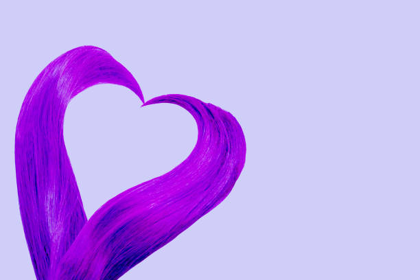 Cut hair tails in shape of heart colored in bright purple on left side of picture on violet rectangle uniform background.Valentines day concept card.Hair and beauty treatment salon. Banner,copy space. corte las colas de pelo en forma de corazón coloreado en púrpura brillante en el lado izquierdo de la imagen sobre el fondo uniforme del rectángulo violeta. tarjeta conceptual del día de san valentín. salón de tratamientos capilares y de belleza. ban