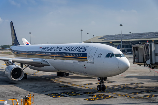 Singapore Airlines plane parked at the Singapore Changi International Airport. Airbus A330-300 is twin-engine twin-aisle wide-body plane airliner.