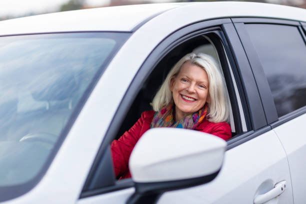 donna sulla sess sess'anni alla guida della sua auto - driving senior adult car women foto e immagini stock