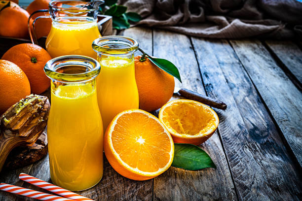 istock Two homemade orange juice bottles on rustic wooden table. Copy space 1206057991