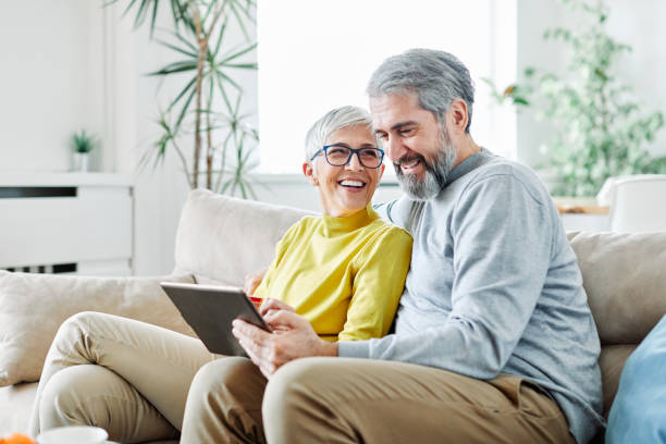 старшие пары счастливы планшетный компьютер любят вместе - women telephone senior adult on the phone стоковые фото и изображения