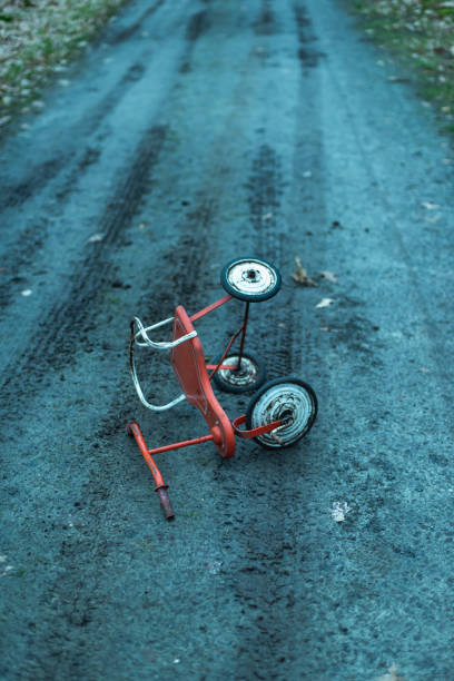 istock Abandoned tricycle dropped on dirt road in forest. 1206058959