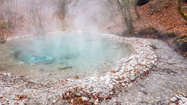 Villach - Natural hot spring in autumn A natural thermic spring in Maibachl, Austria during autumn. The thermic pool is located in the middle of the forest. Healing power of natural water. The steam rises above the water. Relaxation villach stock pictures, royalty-free photos & images
