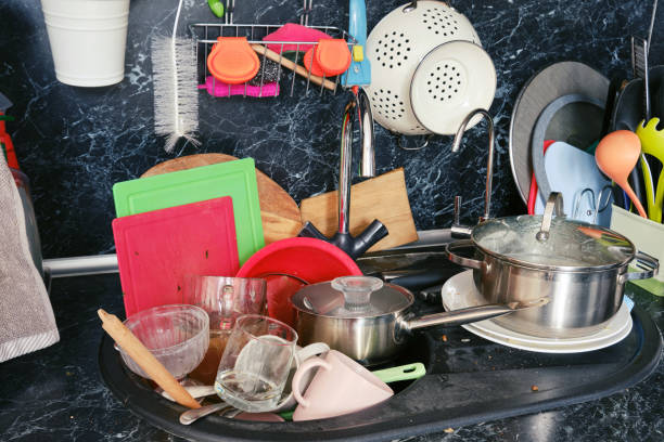 istock Dirty dishes around the sink in a cluttered kitchen 1206062235