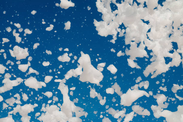 istock White airy foam on a blue sky background. Foamy disco party. 1206066828