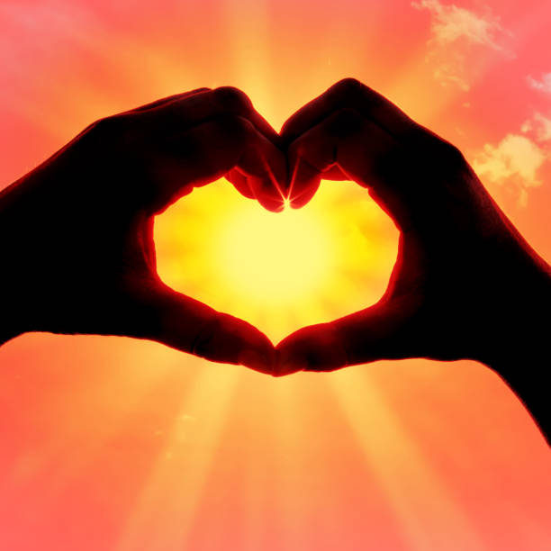 istock Hands forming a heart shape over the sun 1206068263