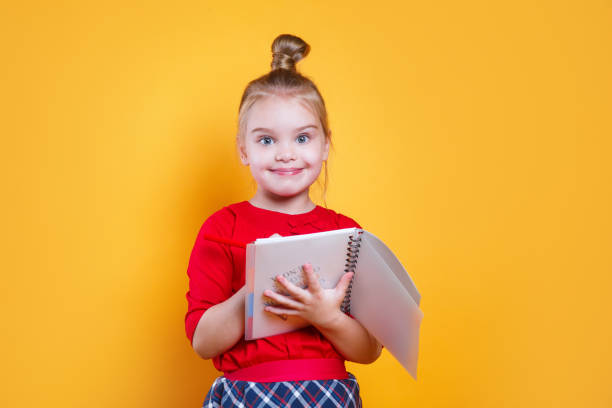 istock Smiling little student girl with notebook. Education and school concept . 1206068404