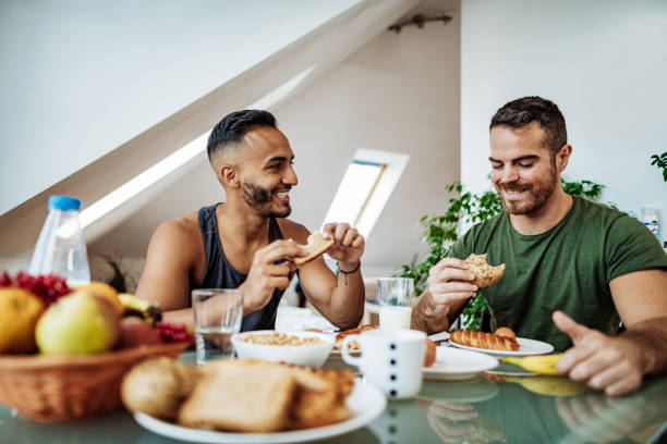 istock Gay couple at home eating breakfast and talking 1206068616