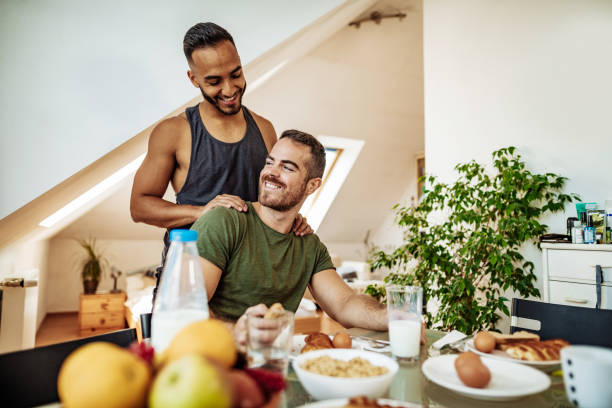 Gay couple at home eating breakfast and talking