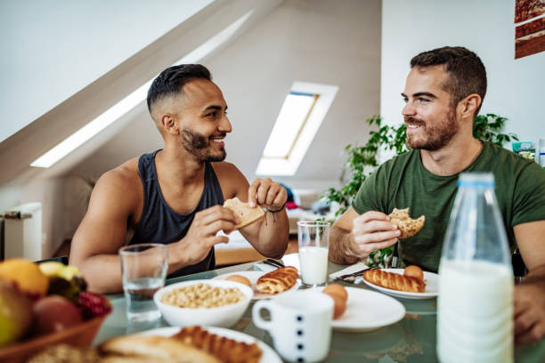 istock Gay couple at home eating breakfast and talking 1206068706