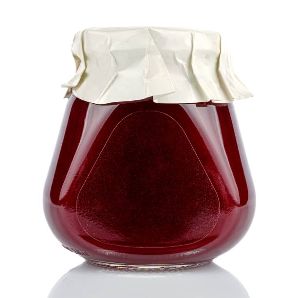 molho de cranberry em um frasco de vidro cônico fechado com uma tampa enrolada em papel branco isolado em fundo branco - relish jar condiment lid - fotografias e filmes do acervo