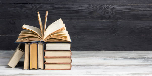 istock Open book, hardback books on wooden table. Back to school. Copy space. 1206072455