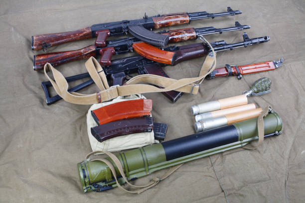 several ak 47 on canvas with ammunitions on canvas several ak 47 on canvas with ammunitions on canvas background ak 47 violence industry black stock pictures, royalty-free photos & images