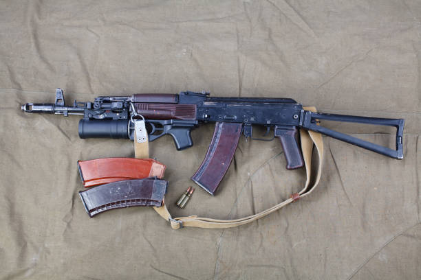 Kalashnikov AK 74 with underbarrel grenade launcher and ammunitions on canvas Kalashnikov AK 74 with underbarrel grenade launcher and ammunitions on canvas background ak 47 violence industry black stock pictures, royalty-free photos & images