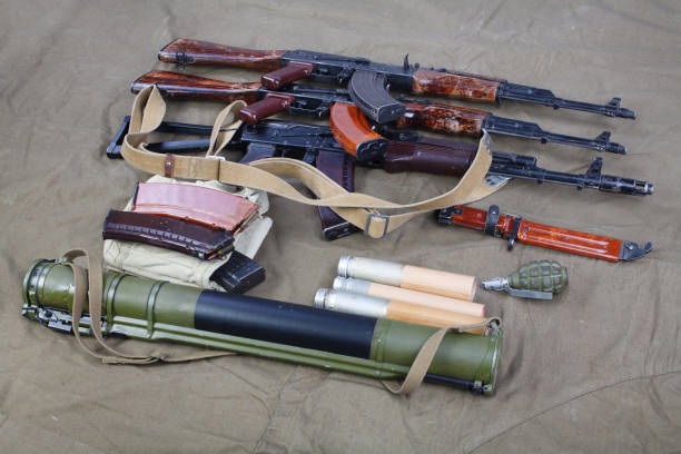 several ak 47 on canvas with ammunitions on canvas several ak 47 on canvas with ammunitions on canvas background ak 47 violence industry black stock pictures, royalty-free photos & images