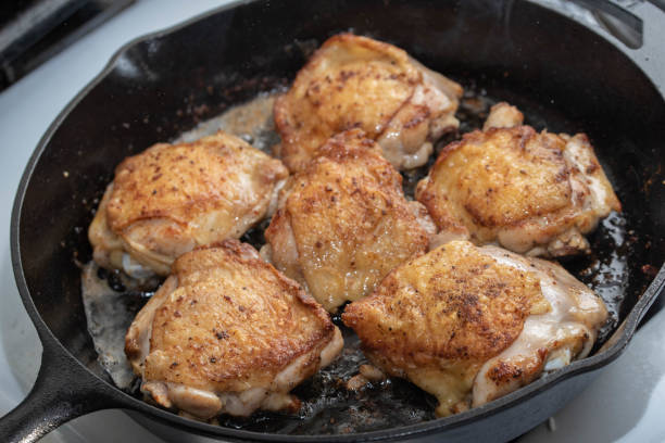 istock cooking chicken thigh on iron skillet 1206073639