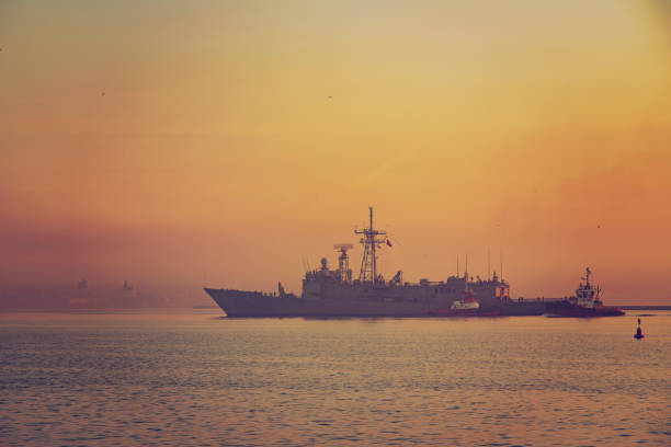 Panorama of the battleship leaving the harbor at sunrise.