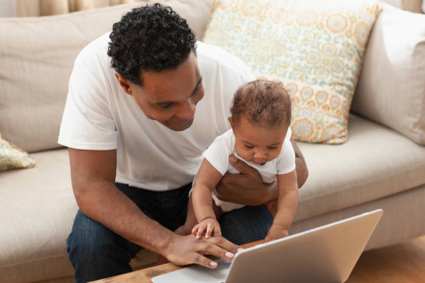 istock Father and baby girl using laptop on table at home 1206073739