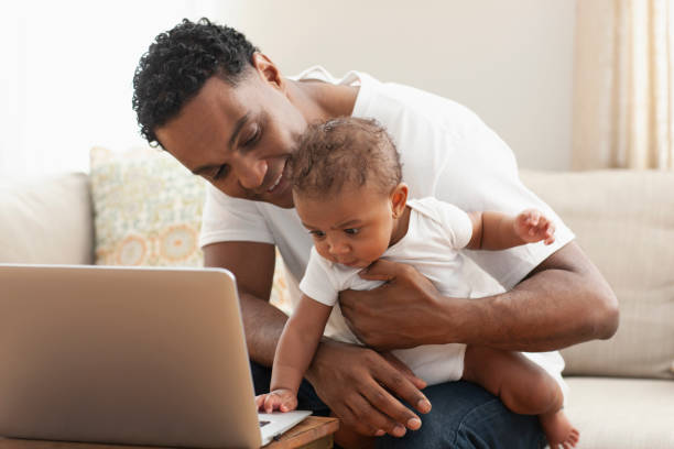 istock Father and baby girl using laptop on table at home 1206073740