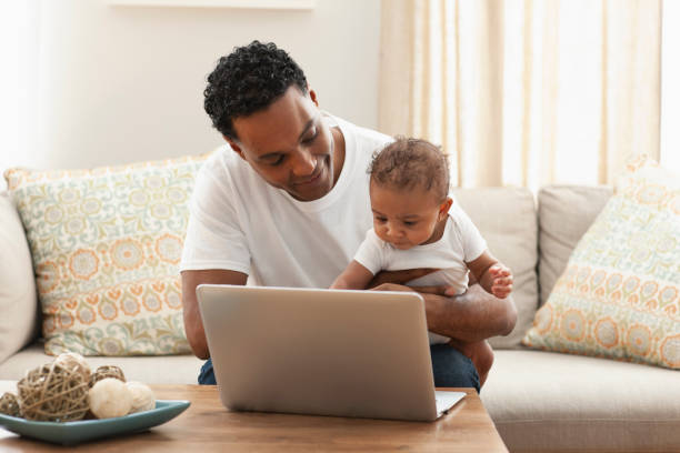 istock Father and baby girl using laptop on table at home 1206073746