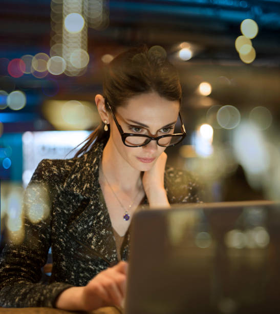 istock Night work woman glass reflections vertical 1206079144