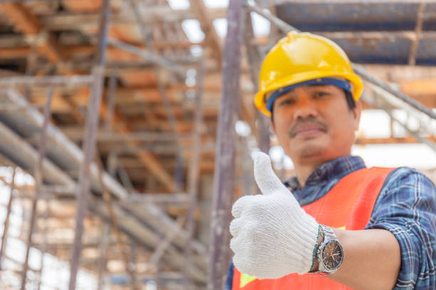 istock Engineer / worker man hand giving thumb up over blurred construction site, Successful concept 1206081948