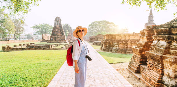 istock Young backpacker Tourist woman with a modern mirrorless camera enjoying walking at ancient ruins during her Asian vacation, Ayutthaya, Thailand. 1206084248