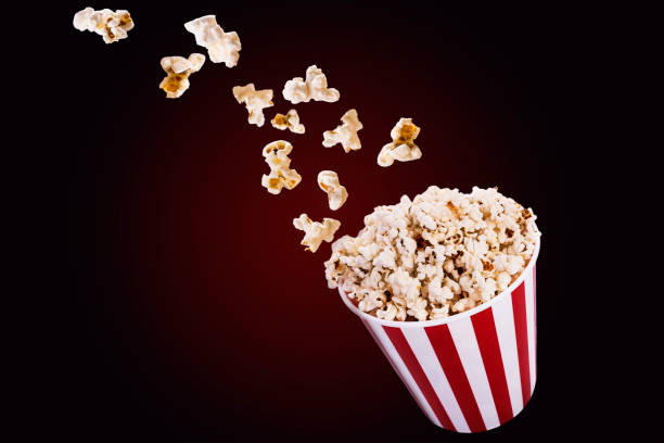istock Flying popcorn from striped bucket isolated on black background 1206084395
