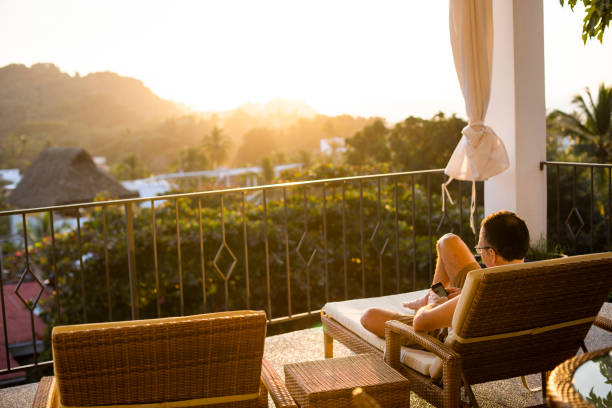 istock Man relaxing on balcony with a view on the jungle, Nayarit, Mexico 1206085403