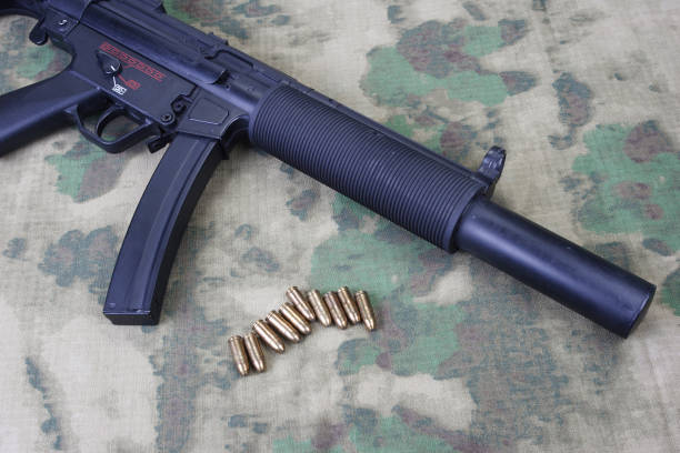 istock submachine gun MP5 with silencer on camouflaged background 1206087701